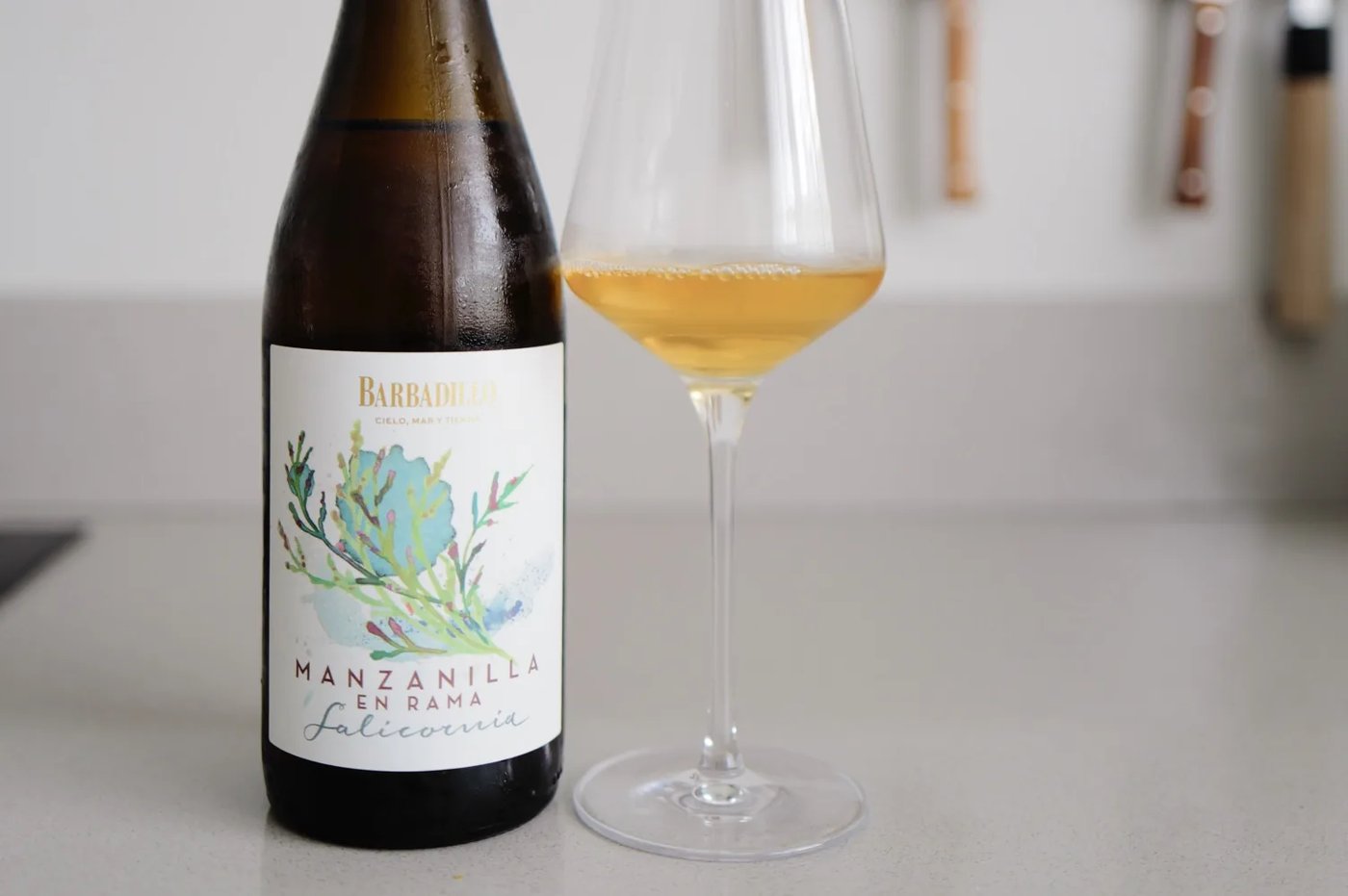 Fles Barbadillo Salicornia Manzanilla en Rama naast een glas goudgele manzanilla