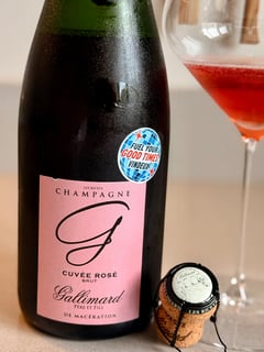 Fles Champagne Gallimard Cuvée Rosé uit Les Riceys met Vindeux-sticker naast een glas diep roodroze champagne