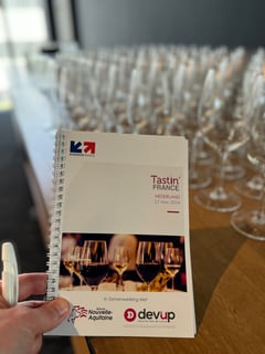 Glazen met Franse wijnen op een proeftafel tijdens Tastin' France 2024 in Amsterdam.
