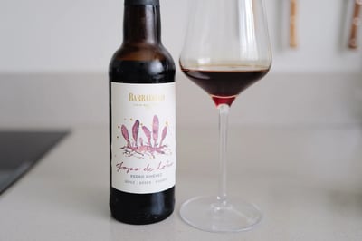 Bottle of Barbadillo Jopo de Lobo Pedro Ximénez beside a glass of dark red PX