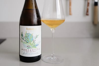 Bottle of Barbadillo Salicornia Manzanilla en Rama beside a glass of golden manzanilla