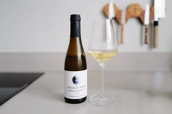 Halve fles Pouilly-Fumé Terres Blanches 2023 van Domaine du Bouchot naast een ingeschonken glas
