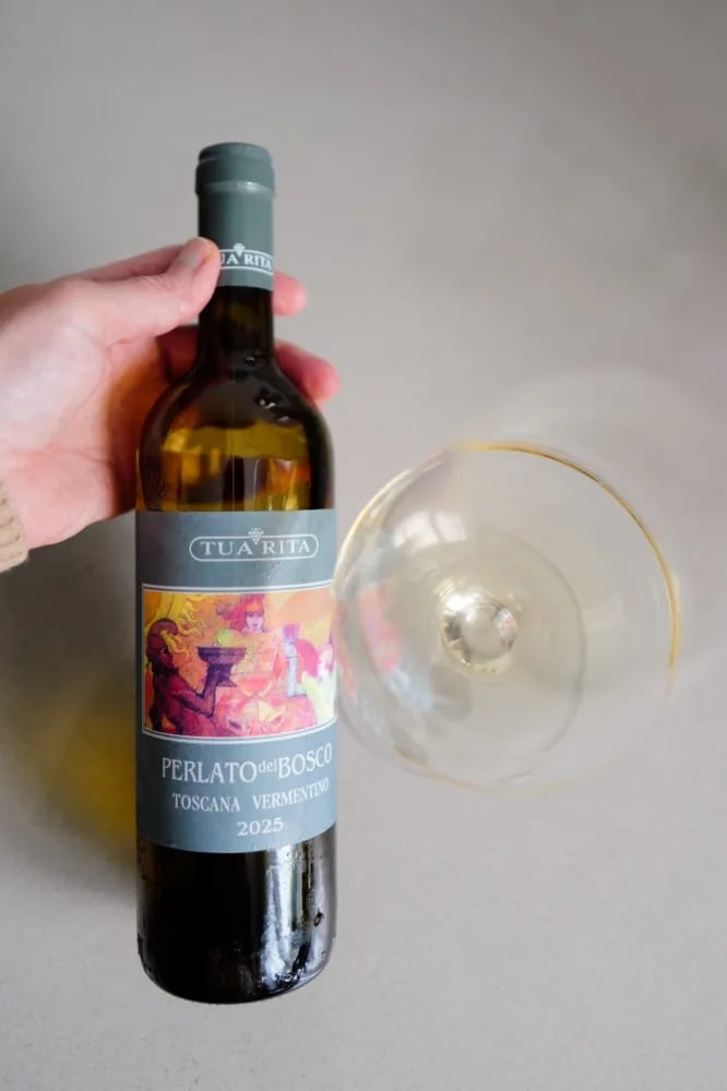 Glas Perlato del Bosco Vermentino 2025 wordt gekanteld naast de fles