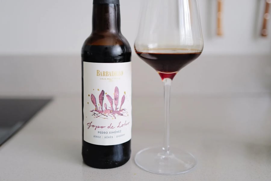 Fles Barbadillo Jopo de Lobo Pedro Ximénez naast een glas donkerrode PX