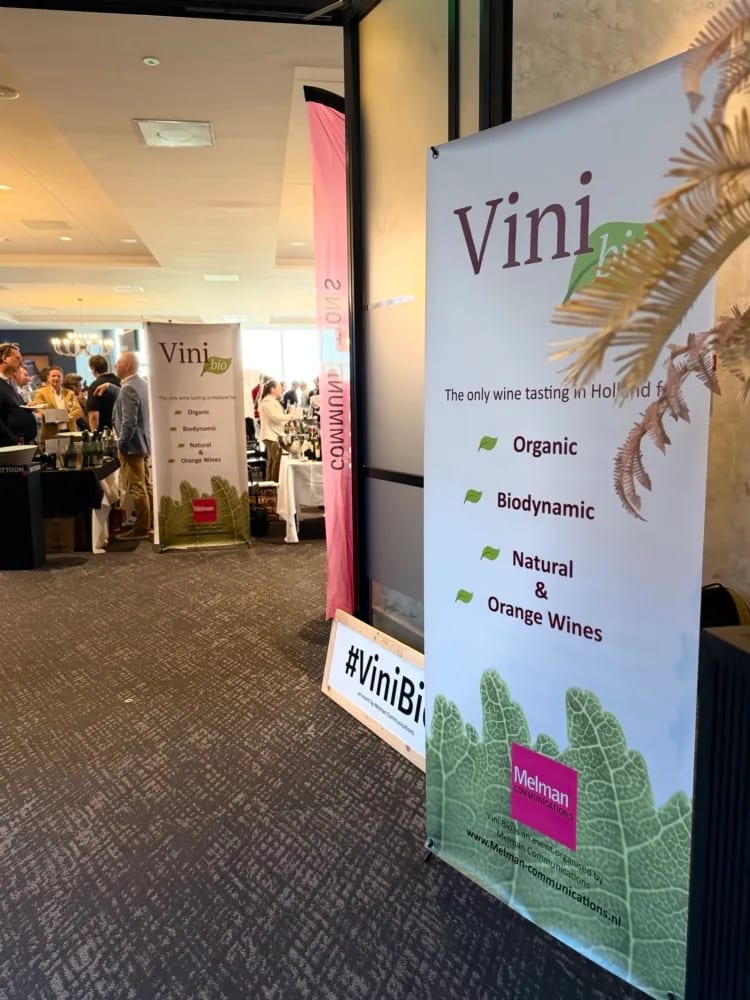 Ingangsgalerij ViniBio 2026 met banners en hashtag-bord