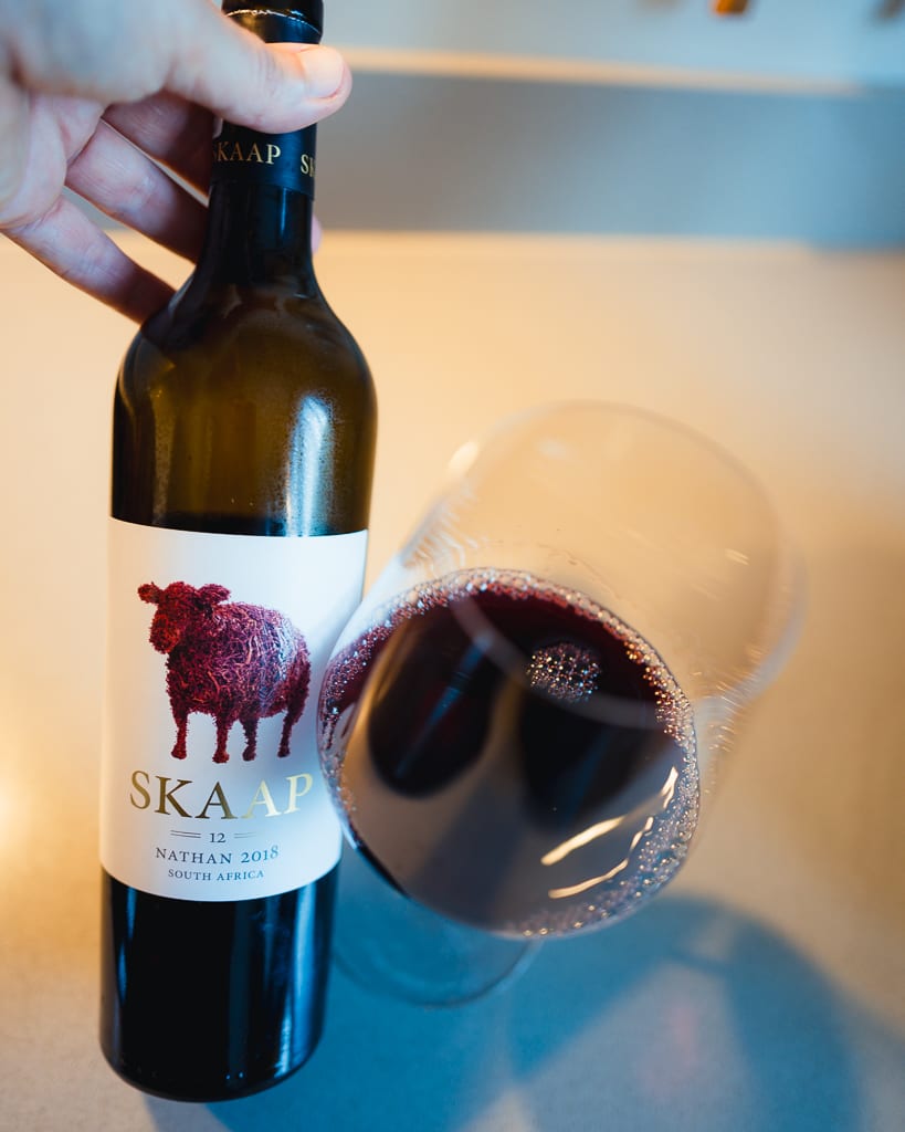 Vijf waardevolle wijnen wereldwijd geselecteerd door Wijnadvies, gepresenteerd op een tafel