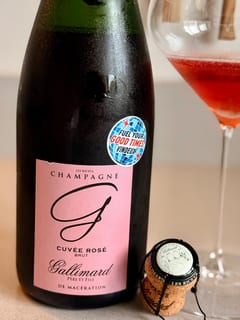 Fles Champagne Gallimard Cuvée Rosé uit Les Riceys met Vindeux-sticker naast een glas diep roodroze champagne