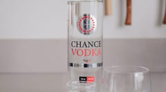 Fles Chance Vodka op een tafel met een glas op ijs ernaast