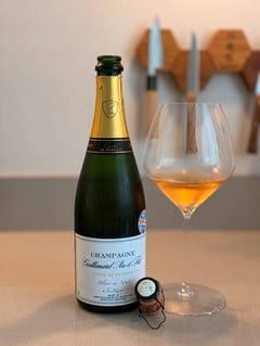 Fles Champagne Gallimard Cuvée de Réserve Blanc de Noirs naast een glas koperkleurige champagne
