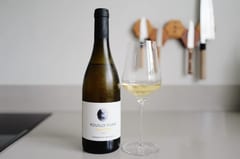 Fles Pouilly-Fumé Caillottes 2023 van Domaine du Bouchot naast een ingeschonken glas
