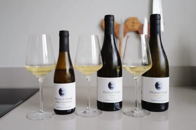 Drie flessen Pouilly-Fumé van Domaine du Bouchot naast elkaar met drie ingeschonken glazen