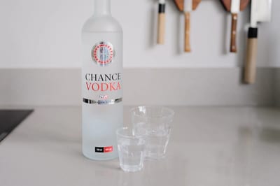 Fles Chance Vodka met roulettelogo naast twee glazen op het aanrecht