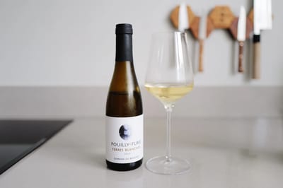 Halve fles Pouilly-Fumé Terres Blanches 2023 van Domaine du Bouchot naast een ingeschonken glas