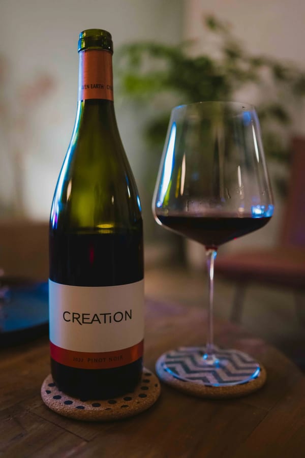 Creation Estate Pinot Noir 2022 fles uit Zuid-Afrika naast een glas