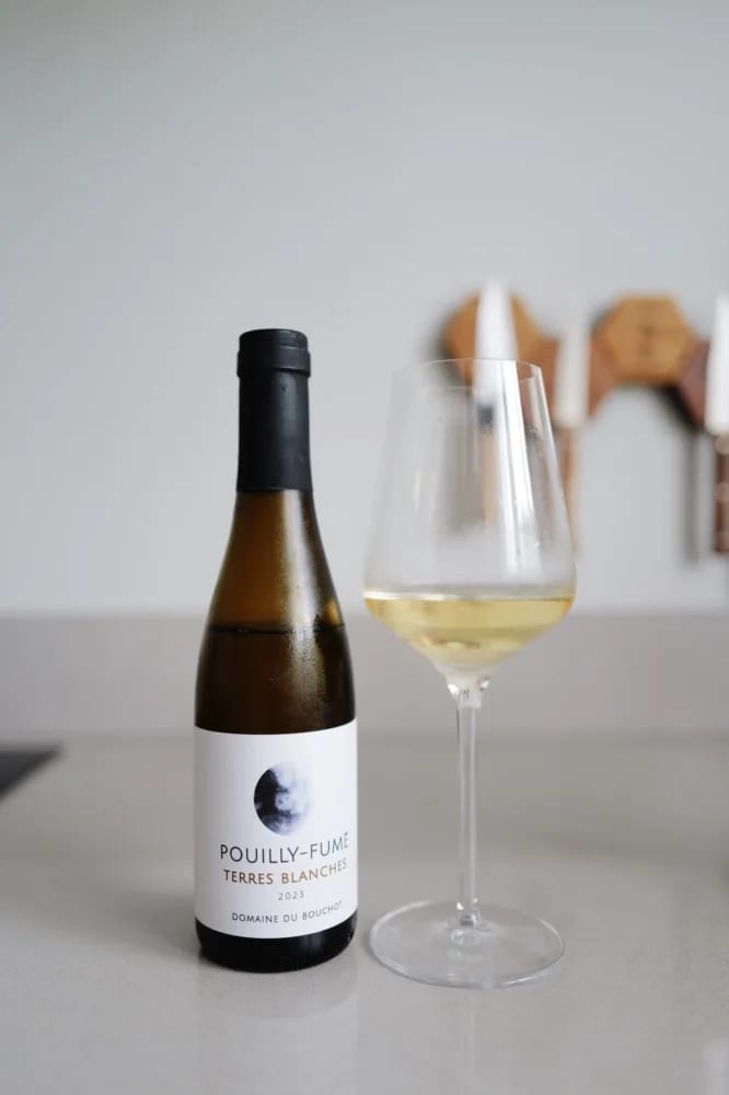 Fles Pouilly-Fumé Terres Blanches 2023 van Domaine du Bouchot naast een ingeschonken glas